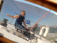 Photo by Mark BarrettDiana at the helm. Seasickness? Fear of heeling? Remarkably they were non-issues during the indoctrination process.