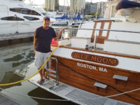 Photo courtesy Walter Hope Jr.Walter Hope III, poses on the swim platform of Blue Moon at Liberty Landing Marina, N.J., after applying the new homeport decal.