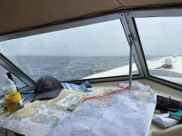 Although the weather for much of the author’s journey was foggy and rainy, he remained comfortable under his boat’s comvertible top. At left, a rare bit of good weather allowed him to drop the top.