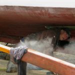 Plank is about done steaming. Foy is ready to begin putting it in place.