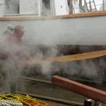 Foster and Jimmy are about to hand the plank to Foy who is behind the steam.